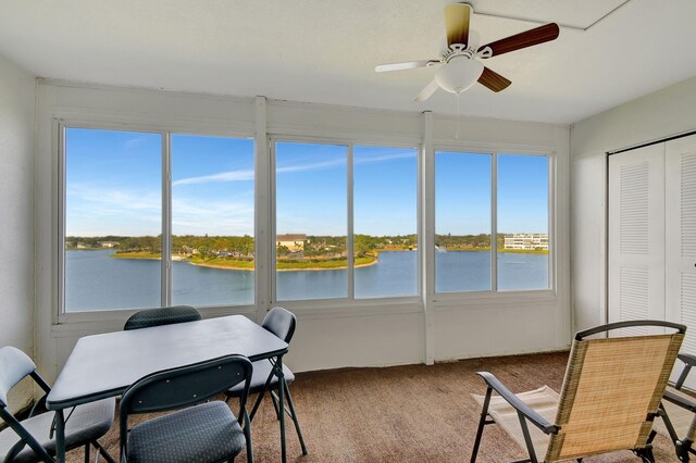 sunroom featuring a water view