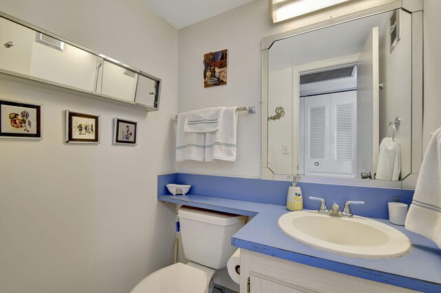 half bath featuring toilet and vanity