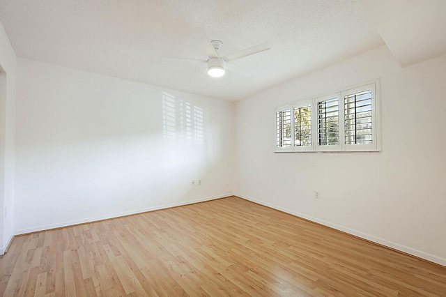 empty room with a ceiling fan, wood finished floors, and baseboards