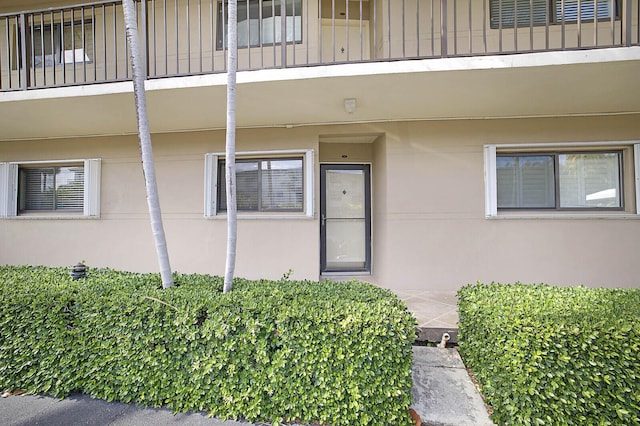 doorway to property with stucco siding and a balcony