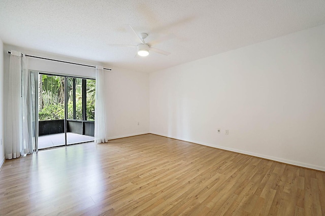 spare room with light wood finished floors, a ceiling fan, and baseboards