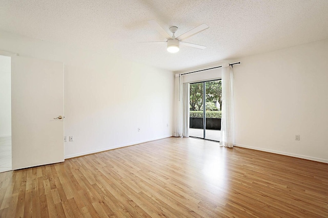 spare room with light wood-type flooring, a textured ceiling, a ceiling fan, and baseboards