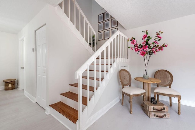 stairway featuring baseboards and wood finished floors