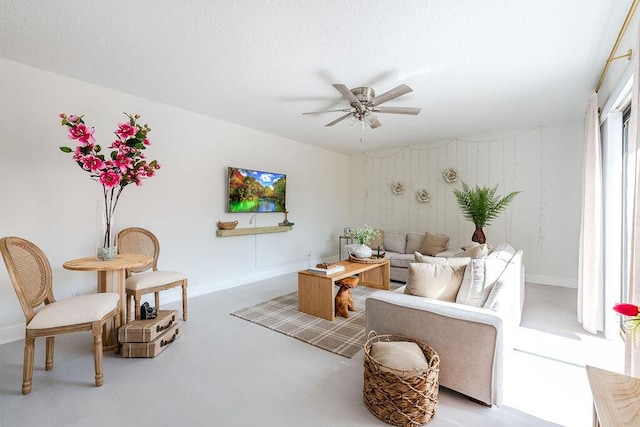 living room featuring a ceiling fan and baseboards