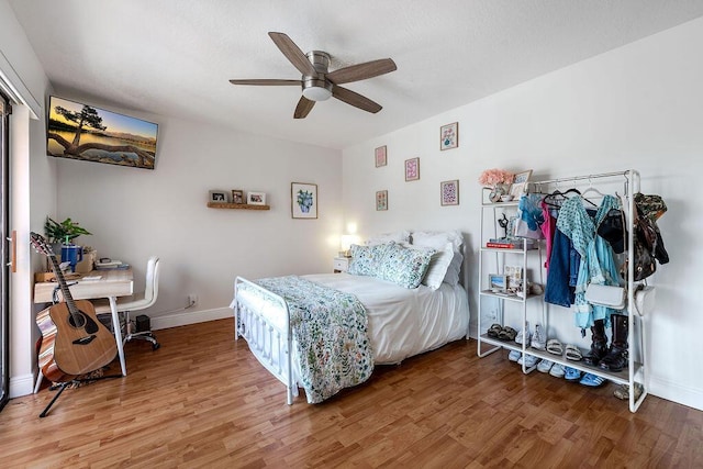 bedroom with wood finished floors, baseboards, and ceiling fan