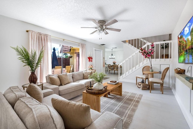 living room with stairs, ceiling fan, a textured ceiling, and baseboards