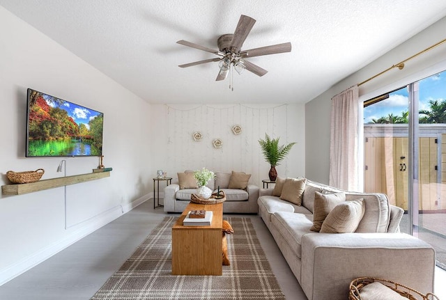 living room with a ceiling fan, dark wood-style flooring, a textured ceiling, and baseboards