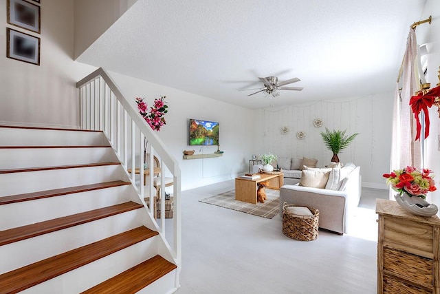 staircase with ceiling fan, wood finished floors, and baseboards