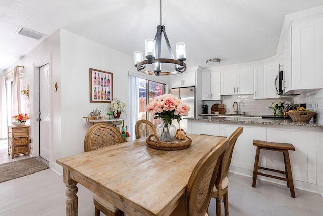 dining room with a chandelier and light wood-style flooring