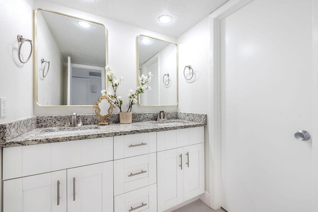 bathroom with double vanity and recessed lighting