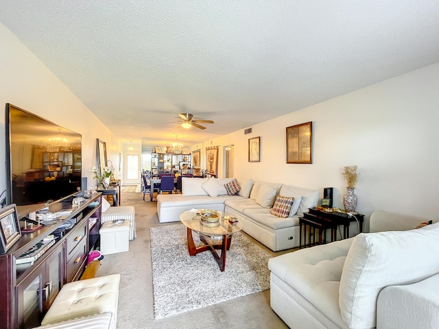 living room featuring a chandelier, light colored carpet, ceiling fan, and a textured ceiling