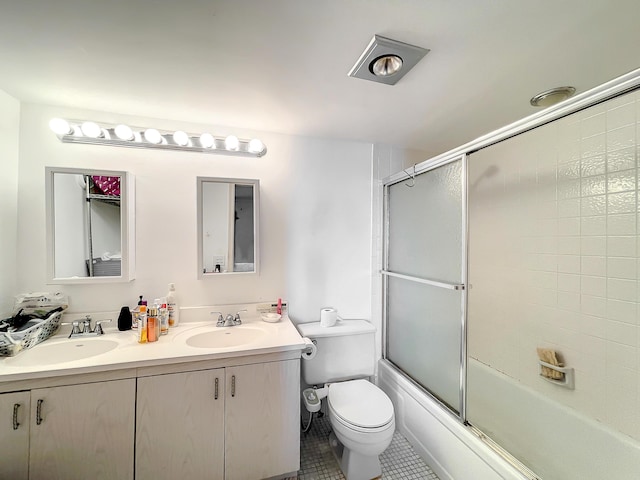 bathroom with tile patterned flooring, toilet, combined bath / shower with glass door, and double vanity