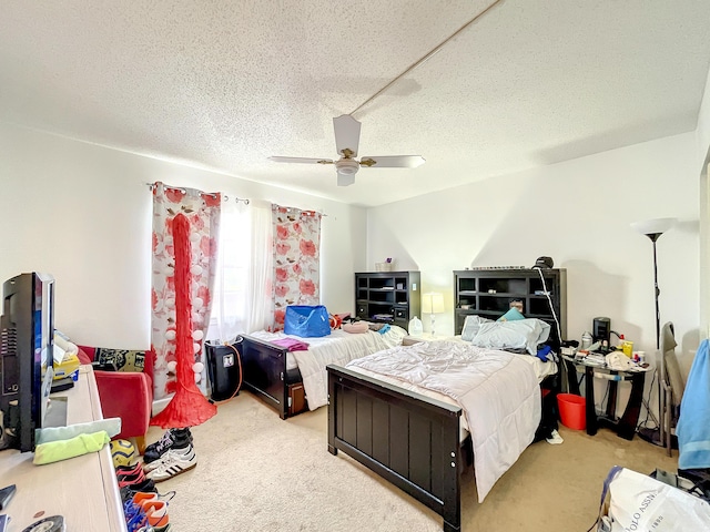 bedroom featuring light colored carpet, ceiling fan, and a textured ceiling