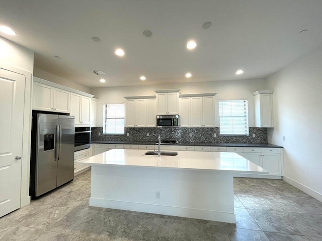 12913 Alton Rd, Palm Beach Gardens, FL 33418 - kitchen with appliances with stainless steel finishes, a sink, tasteful backsplash, a center island with sink, and plenty of natural light