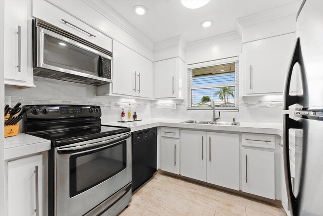 kitchen featuring appliances with stainless steel finishes, a sink, ornamental molding, light countertops, and decorative backsplash