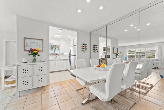 dining space with recessed lighting, light tile patterned flooring, and a textured ceiling