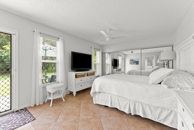 bedroom featuring light tile patterned floors, a textured ceiling, and ceiling fan