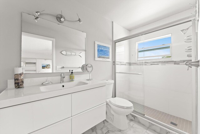 full bathroom with a shower stall, toilet, marble finish floors, and vanity