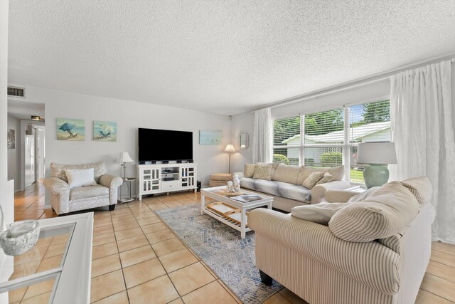 living room with tile patterned floors and a textured ceiling
