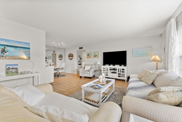 tiled living area with a textured ceiling and recessed lighting