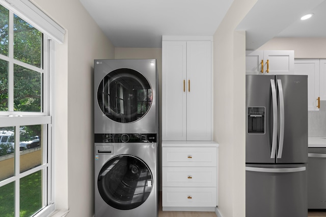 laundry room with stacked washing maching and dryer, laundry area, a healthy amount of sunlight, and recessed lighting