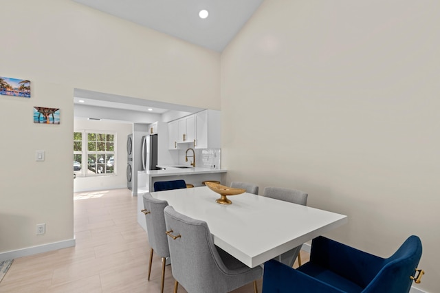 dining area featuring stacked washer and clothes dryer, baseboards, and recessed lighting