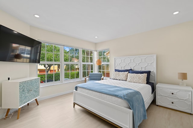 bedroom with wood finished floors, baseboards, and recessed lighting