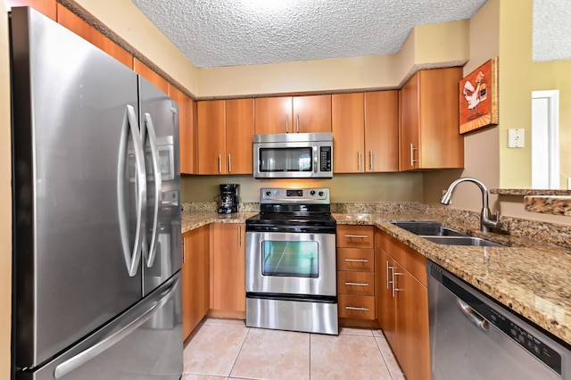 1125 Crystal Way Unit I, Delray Beach, FL 33444 - kitchen featuring stainless steel appliances, a sink, brown cabinets, and a textured ceiling