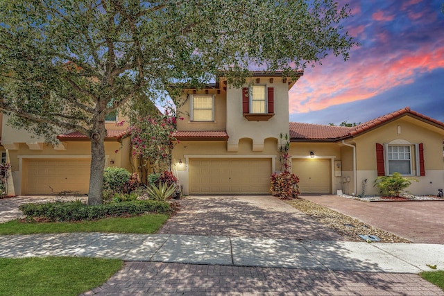 5742 NW 119th Ter, Coral Springs, FL 33076 - mediterranean / spanish home with a tile roof, a garage, stucco siding, and decorative driveway