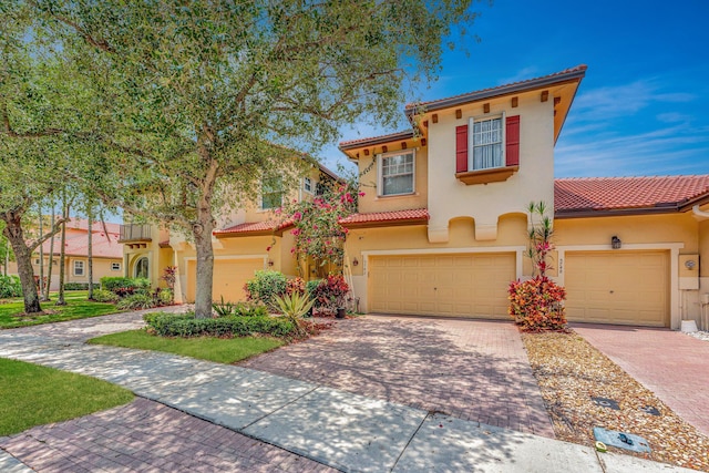 5742 NW 119th Ter, Coral Springs, FL 33076 - mediterranean / spanish-style house featuring stucco siding, an attached garage, a tiled roof, and decorative driveway