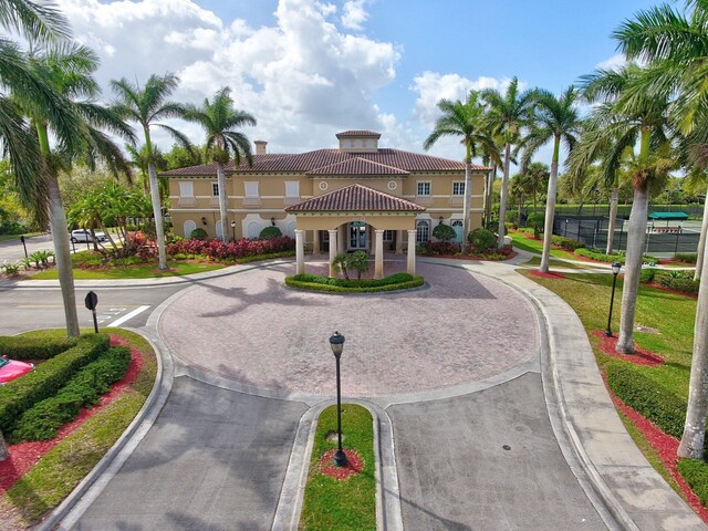 5742 NW 119th Ter, Coral Springs, FL 33076 - view of front of property featuring a tiled roof, stucco siding, a chimney, and curved driveway