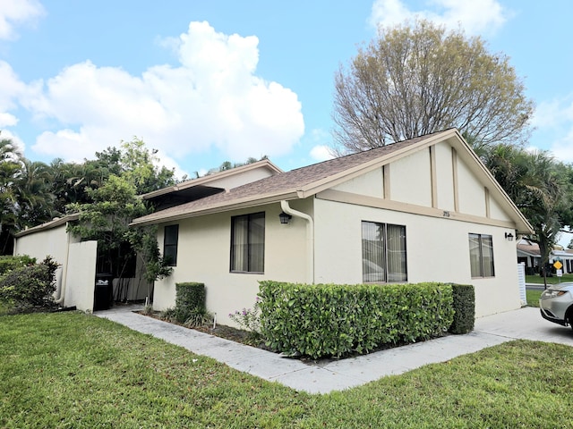 3115 NW 12th St, Delray Beach, FL 33445 - view of property exterior with a yard, a shingled roof, and stucco siding