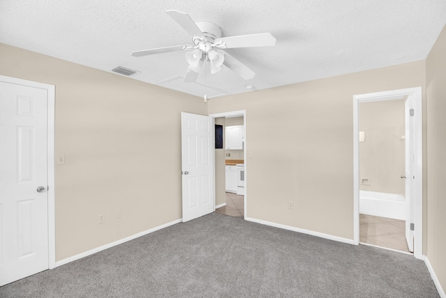 2015 Oleander Blvd Unit A, Fort Pierce, FL 34950 - unfurnished bedroom featuring carpet, a textured ceiling, baseboards, ensuite bathroom, and ceiling fan