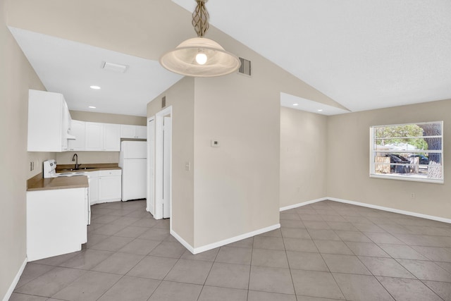 2015 Oleander Blvd Unit A, Fort Pierce, FL 34950 - kitchen with freestanding refrigerator, a sink, light tile patterned floors, white cabinetry, and open floor plan