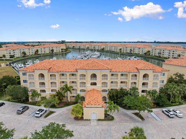 view of property with uncovered parking and a water view