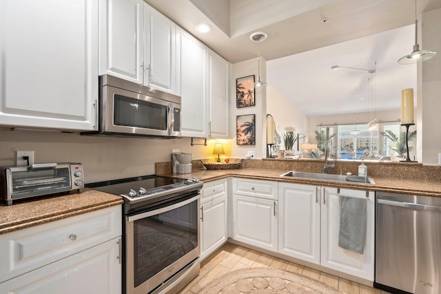 kitchen featuring recessed lighting, a toaster, a sink, white cabinetry, and stainless steel appliances