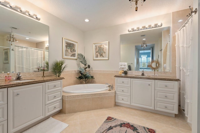 bathroom featuring a sink, two vanities, a garden tub, and tile patterned floors