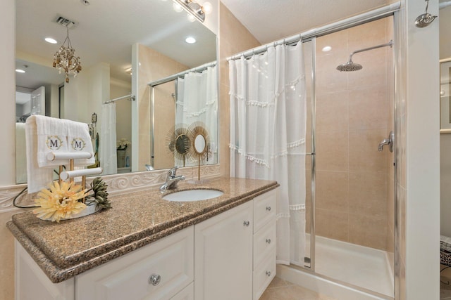 bathroom featuring a stall shower, vanity, visible vents, and recessed lighting