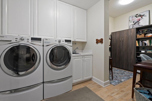 laundry room featuring cabinet space, independent washer and dryer, and light wood-style floors