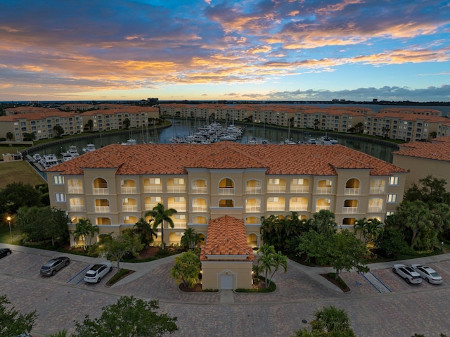 property at dusk with a water view