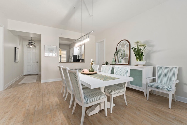 dining space featuring baseboards and light wood-style flooring