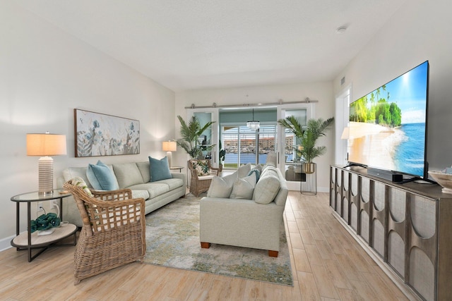 living area featuring light wood-style floors, visible vents, and baseboards