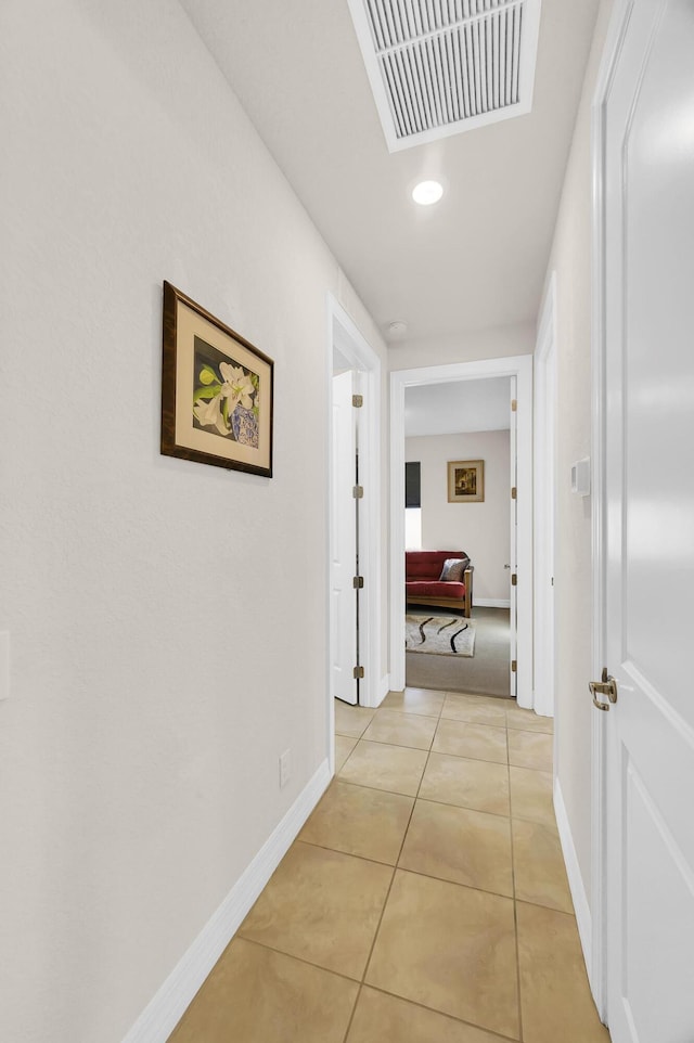 hallway featuring light tile patterned floors, visible vents, baseboards, and recessed lighting