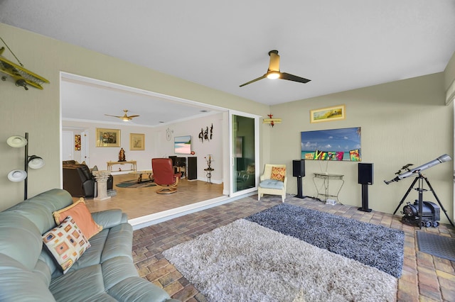 living room with brick floor, baseboards, and a ceiling fan