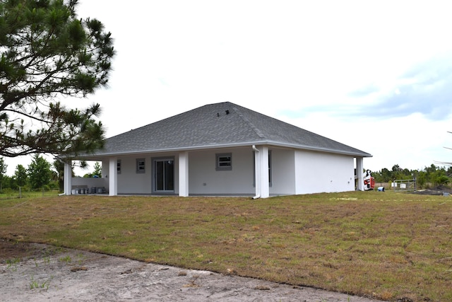 15722 NW 270th St, Okeechobee, FL 34972 - back of property featuring stucco siding, a yard, and a shingled roof