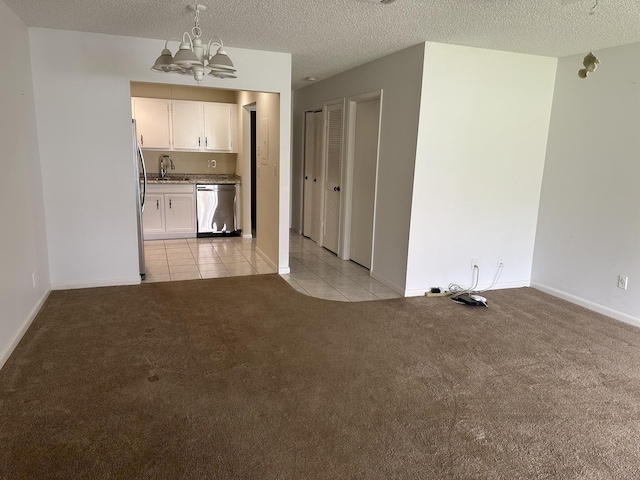 933 Savannas Point Dr Unit C, Fort Pierce, FL 34982 - unfurnished living room with a chandelier, light colored carpet, a sink, light tile patterned floors, and a textured ceiling