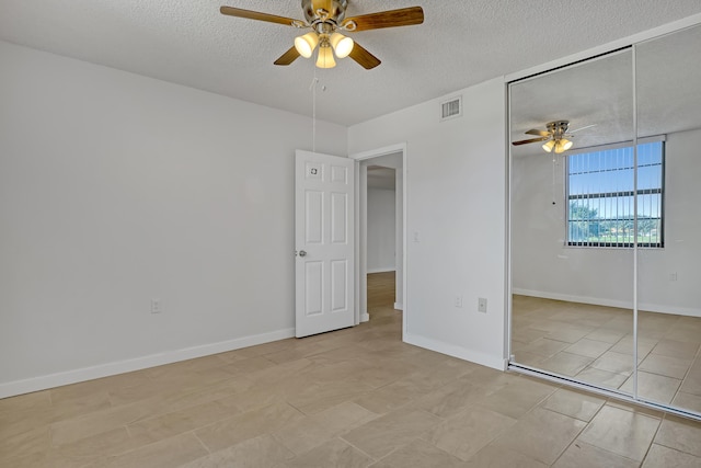 unfurnished bedroom with a closet, a textured ceiling, visible vents, and ceiling fan