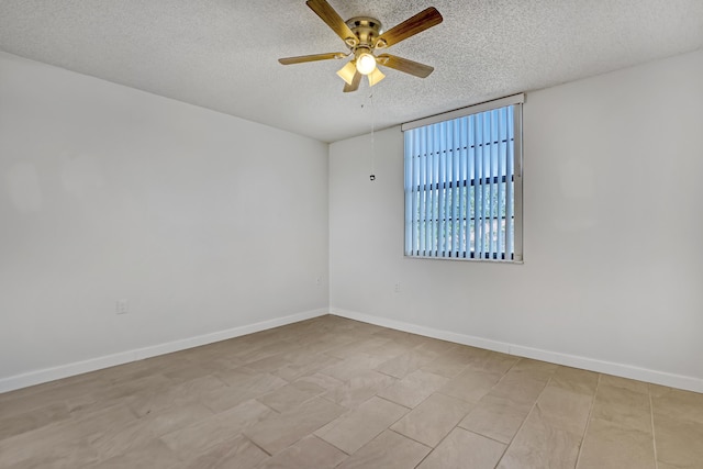 empty room with a textured ceiling, baseboards, and a ceiling fan