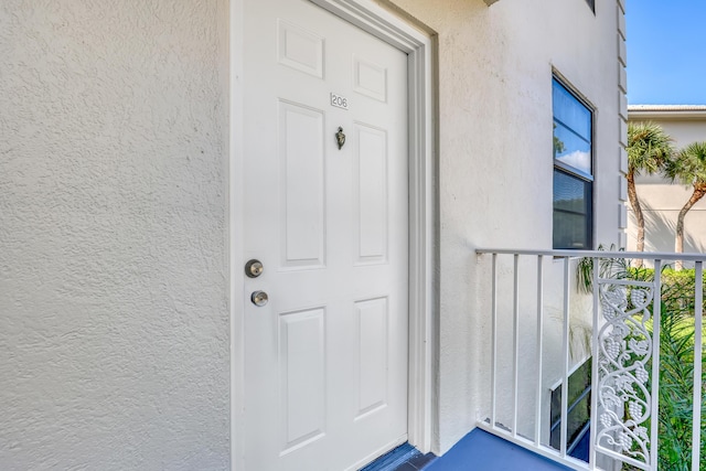 doorway to property featuring stucco siding
