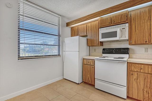 kitchen with white appliances, decorative backsplash, light countertops, light tile patterned floors, and baseboards